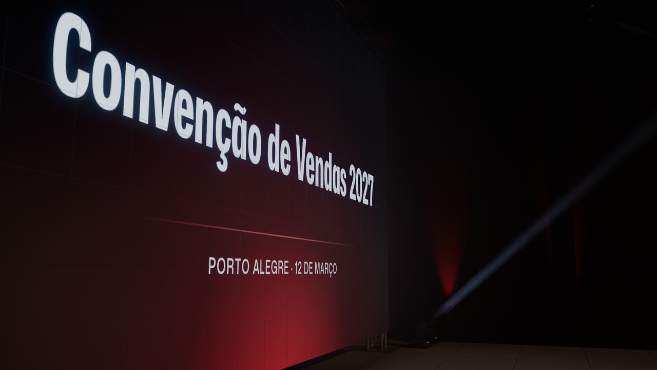 O painel de LED de 8 por 4,5 metros visto da lateral do palco, com o nome do evento no ar.